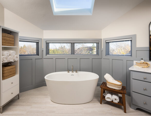 Close up of beautiful blue wainscotting surrounds stand-alone tub in Boyer Building remodel.