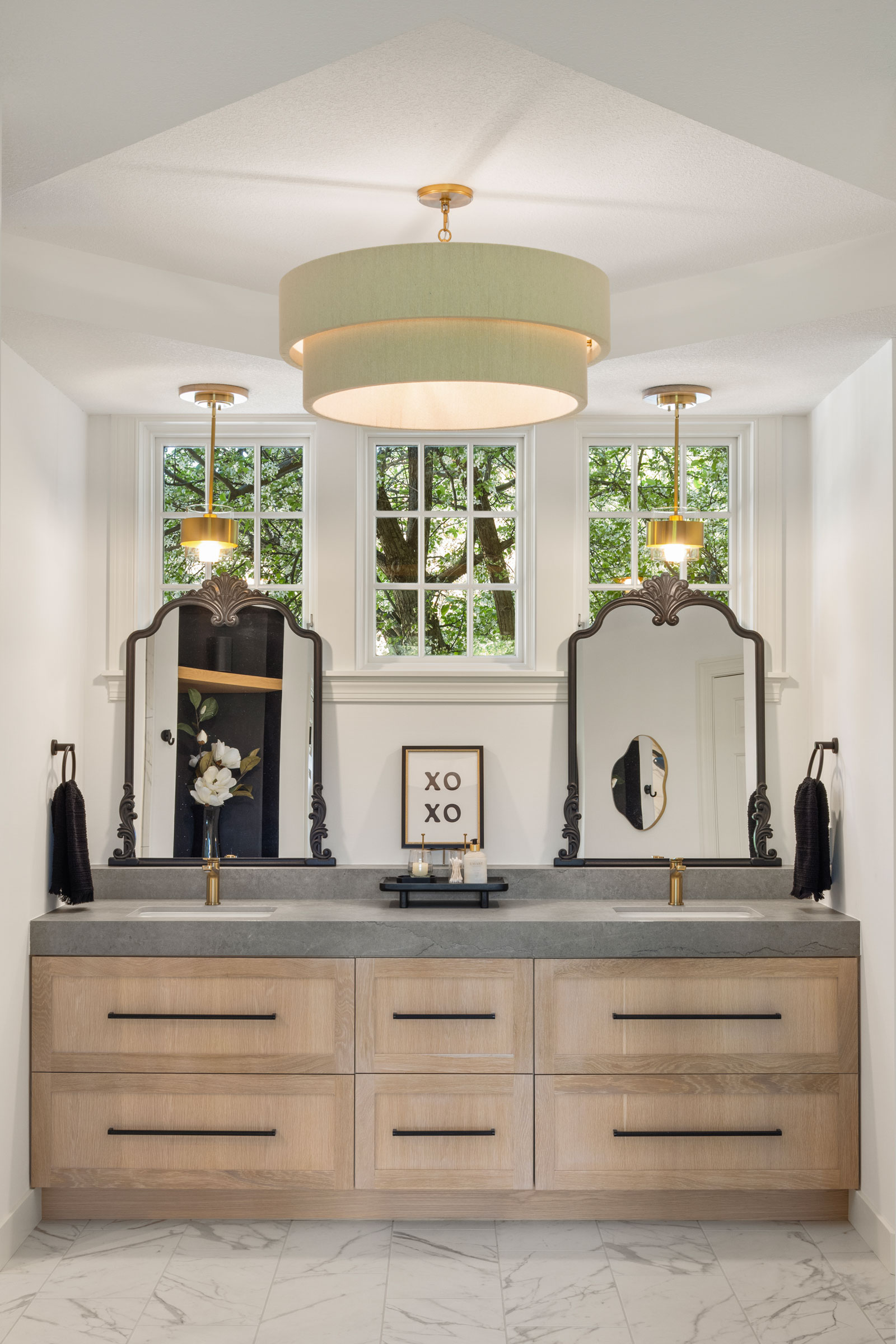 Beautiful white oak double sink vanity set on large format tile of 12z24 porcelain tile.