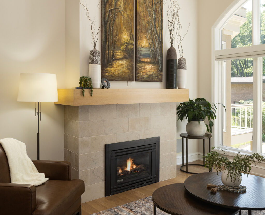 Lovely after photo of remodeled living room fireplace with limestone surround and new hearth.