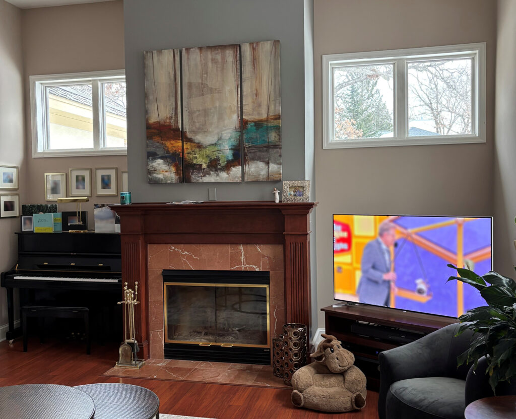 Before family room with outdated fireplace surround and lack of storage.