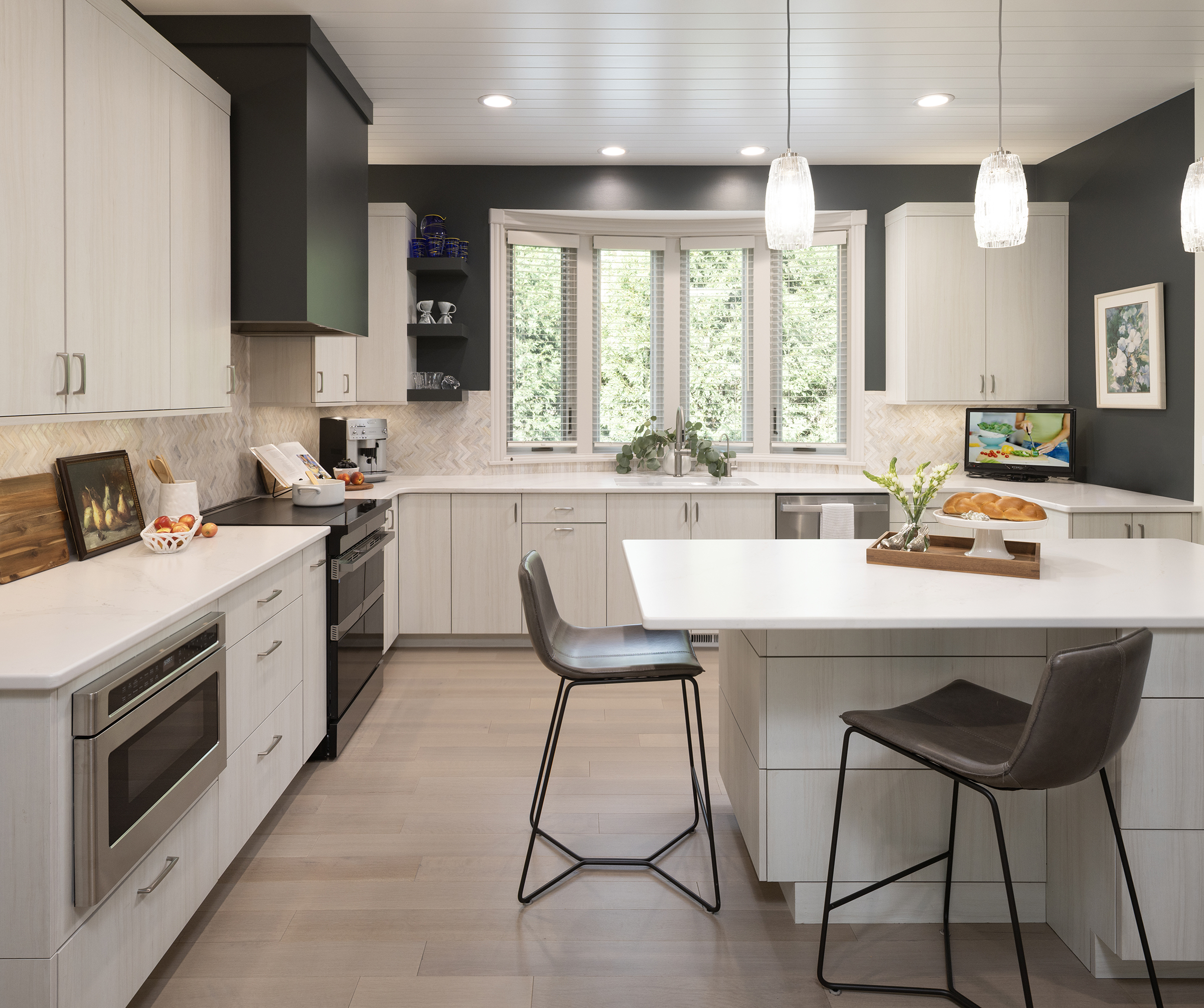 Townhome kitchen with dark charcoal painted walls to accent off the white oak cabinetry and white counter and ceramic tilework.