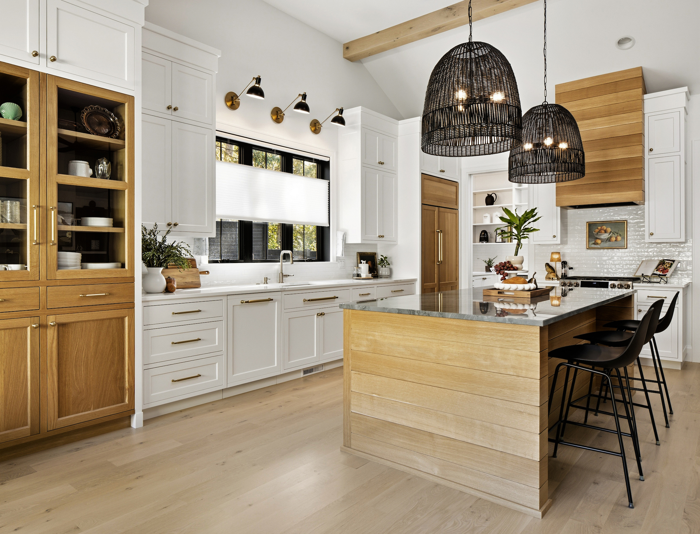 White Boyer Building Custom Home Kitchen with rattan pendant lights and white oak island with white perimeter natural stone countertops.